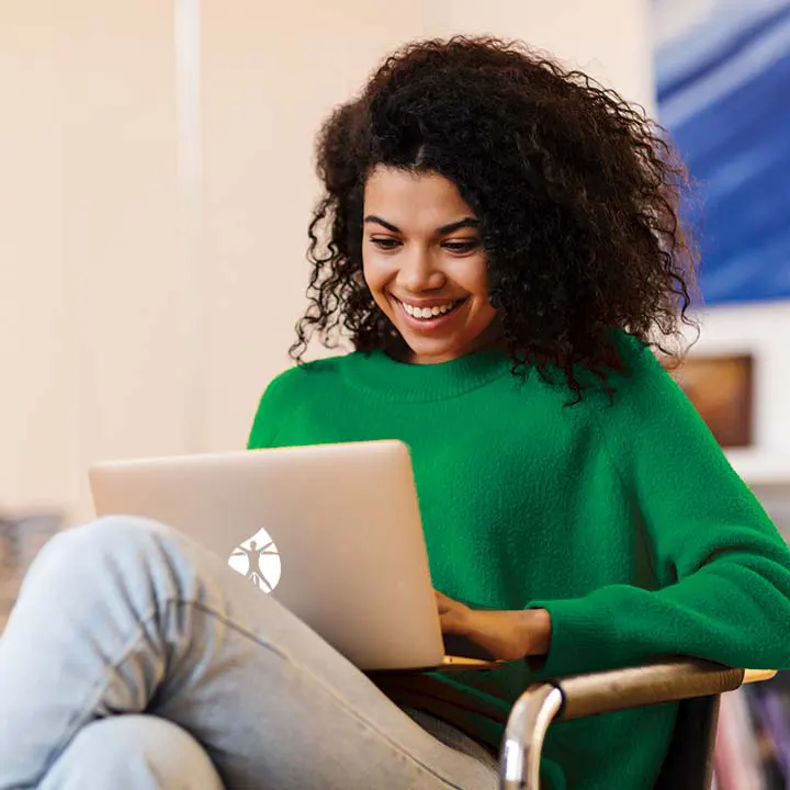 Woman with green sweater working on laptop