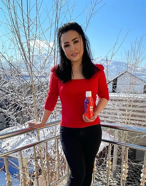 Woman in red sweater on the balcony holding NutraBurst